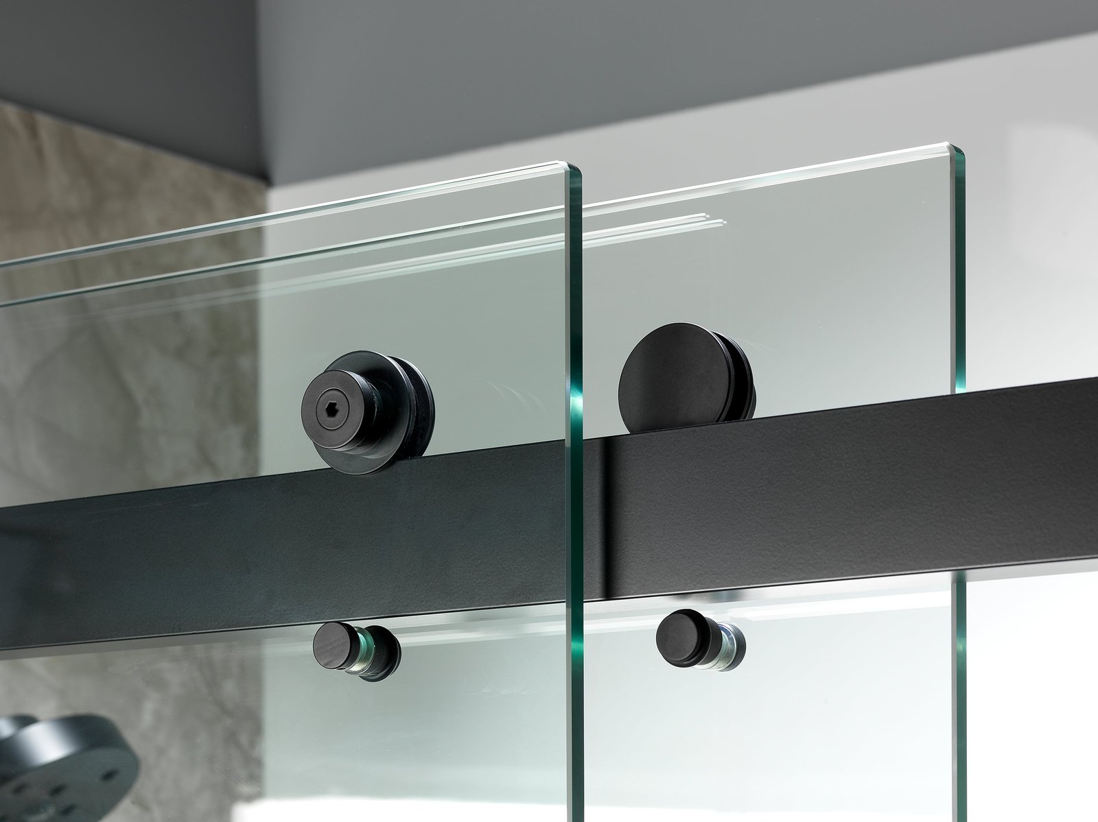 Modern frameless glass shower enclosure with a stone-look surround