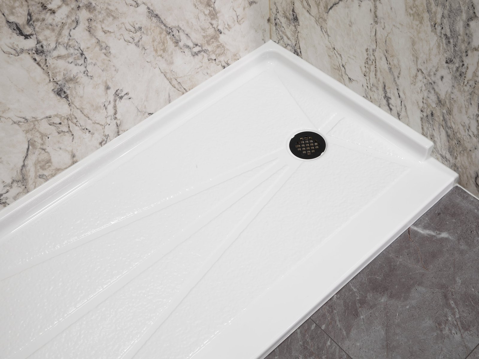 Low-maintenance marble-look shower base with easy-clean walls
